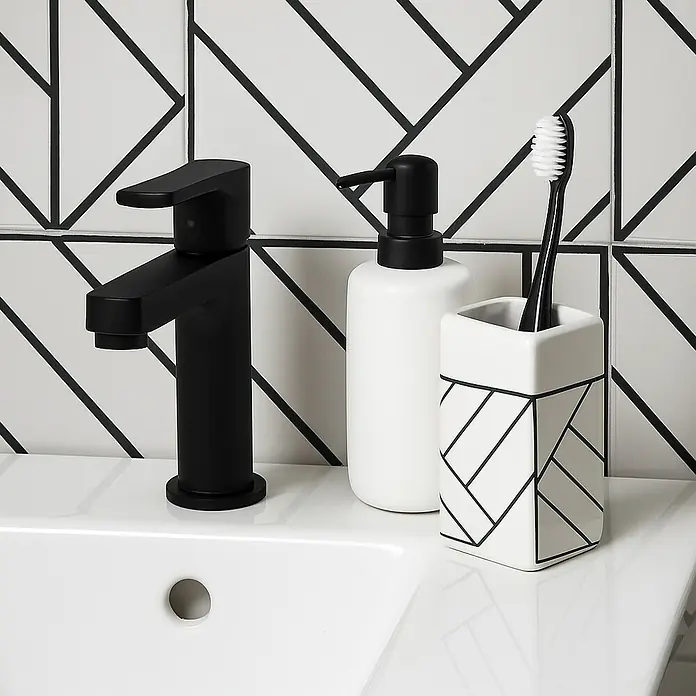 MSV Monolithic Portacepillos - L x An x Al: 67 x 67 x 104 cm, Cerámica - Moderno conjunto de baño con grifo negro, dispensador de jabón y portacepillos sobre un lavabo blanco frente a azulejos estampados.