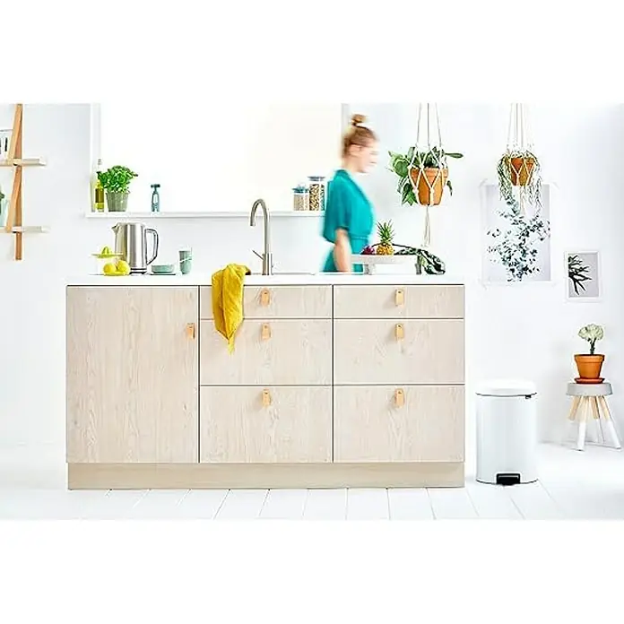 Proregal Treteimer Brabantia Klassischer Tretmülleimer mit Soft-Verschluss - 20 l, Metall, Weiß - Helle Holzküchenschränke mit Griffen aus Lederriemen und eine schlanke Edelstahlspüle in einer minimalistischen Küche.