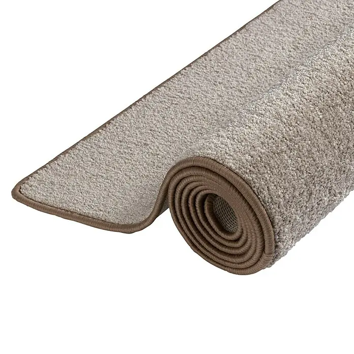 Kurzflorteppich Sundae - Beige, 200 x 200 cm, 100 % Polypropylen - Nahaufnahme eines aufgerollten Teppichs mit beiger Oberfläche und brauner Einfassung, der eine gemütliche Textur zeigt.