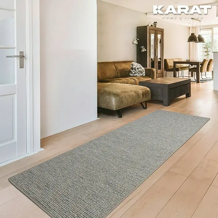 Flachgewebeteppich Geneva - Silbergrau, 200 x 200 cm, 100 % Polypropylen - Ein schmaler, grauer Teppichläufer liegt auf einem hellen Holzboden in einem stilvollen Wohnzimmer. Er fügt sich nahtlos in die moderne Einrichtung ein.