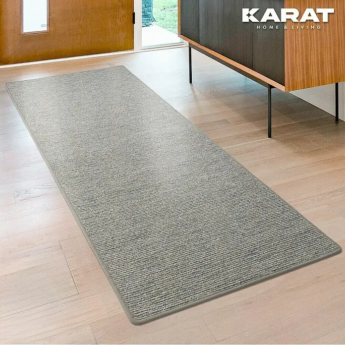 Flachgewebeteppich Geneva - Silbergrau, 200 x 200 cm, 100 % Polypropylen - Ein grauer Läufer liegt auf einem Holzboden in einem Eingangsbereich, der das schlichte und moderne Design des Teppichs hervorhebt.