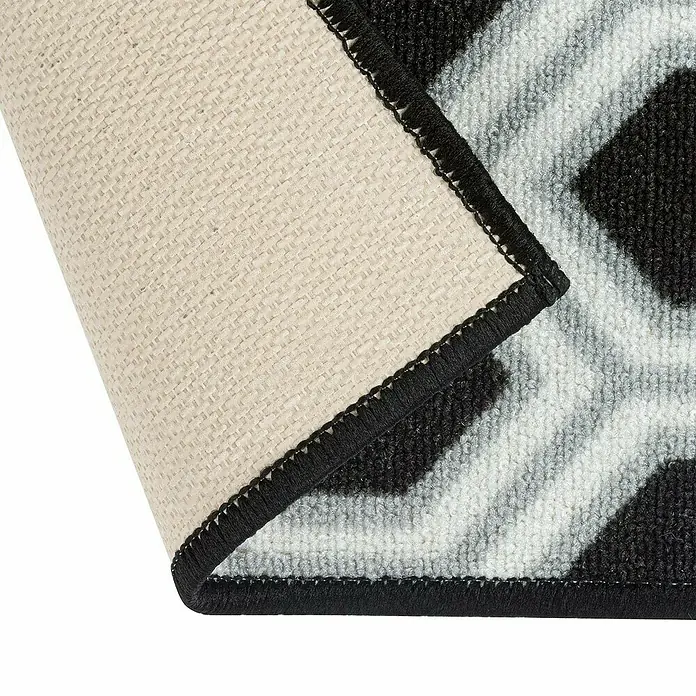 Teppichläufer Bangor - Schwarz/Weiß, 350 x 80 cm, 100 % Polyamid - Nahaufnahme eines Teppichs mit geometrischem Muster und schwarzer Bordüre, der die Textur und Verarbeitung hervorhebt.
