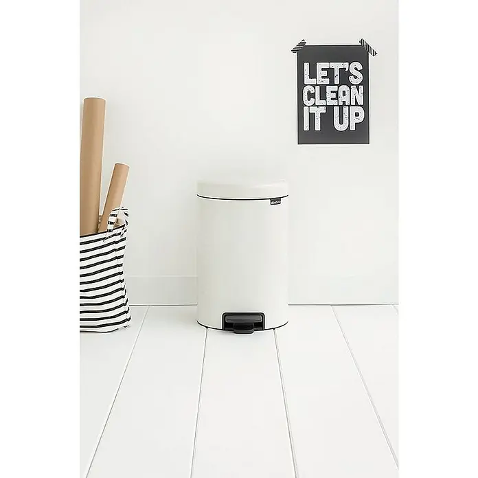 Proregal Treteimer Brabantia Klassischer Tretmülleimer mit Soft-Verschluss - 12 l, Metall, Weiß - Das Bild zeigt einen weißen Treteimer von Brabantia in einem hellen Raum mit einem Poster an der Wand. Praktisch und stilvoll für jeden Haushalt!