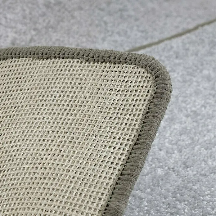 Kurzflorteppich Sundae - Silber, 200 x 200 cm, 100 % Polypropylen - Nahaufnahme einer rutschfesten Teppichunterlage mit grauem Rand. Ideal für glatte Böden.