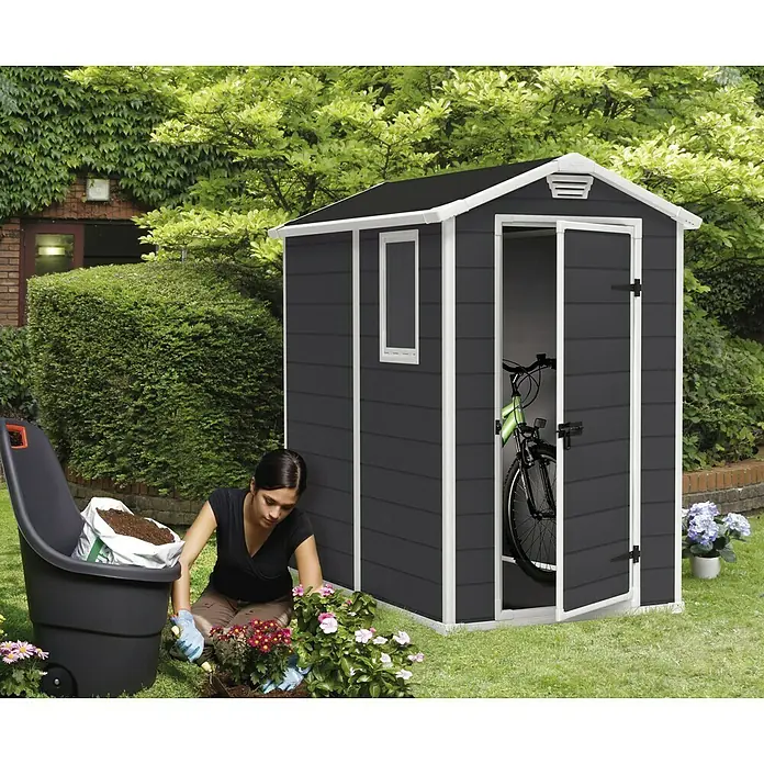 Keter Gerätehaus Manor 4x6 - Außenmaß inkl. Dachüberstand (B x T): 130 x 192 cm, Kunststoff, Anthrazit/Weiß - Gartenhaus mit Fahrrad und Gärtnerin. Ideal für Gartengeräte und Fahrräder. Die Gärtnerin pflanzt Blumen im Garten.