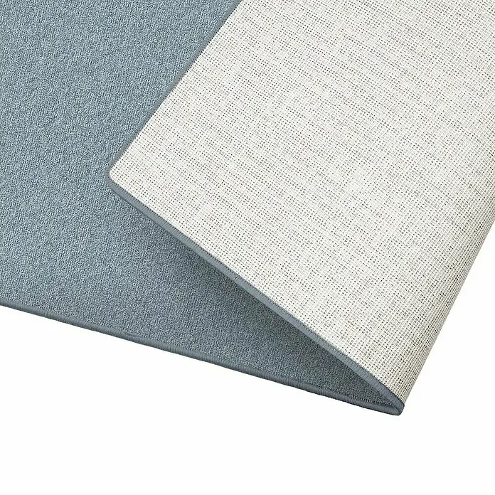 Flachgewebeteppich London - Hellgrau, 100 x 100 cm, 100 % Polypropylen - Nahaufnahme eines hellblauen Teppichs, dessen Ecke hochgeklappt ist und die rutschfeste, weiße Unterseite zeigt.