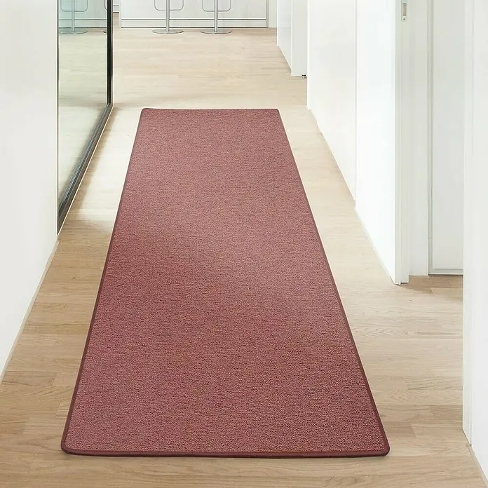 Flachgewebeteppich London - Terra, 200 x 200 cm, 100 % Polypropylen - Ein länglicher, braun-roter Teppich liegt in einem hellen Flur. Der Teppich hat eine schmale, dunklere Umrandung.