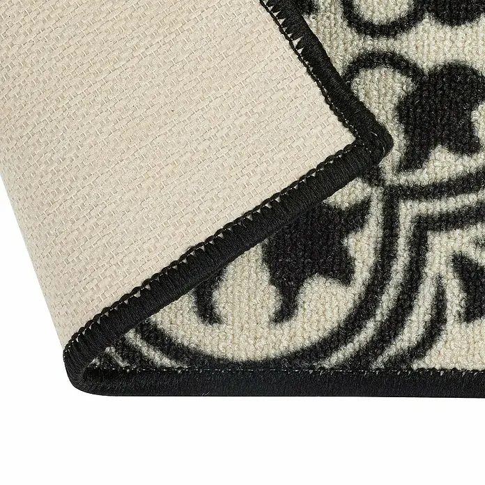 Teppichläufer Galway - Schwarz/Creme, 300 x 80 cm, 100 % Polyamid - Nahaufnahme einer Teppichkante mit schwarzem Rand und Muster, die die Textur und Verarbeitung des Produkts hervorhebt.