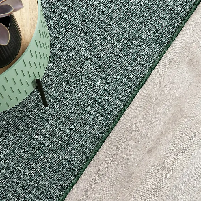 Flachgewebeteppich London - Grün, 100 x 100 cm, 100 % Polypropylen - Nahaufnahme eines mintgrünen Teppichs neben einem hellen Holzboden, der Textur und Farbe hervorhebt.