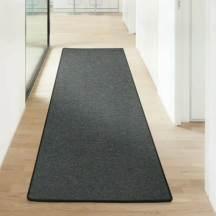 Flachgewebeteppich London - Anthrazit, 100 x 100 cm, 100 % Polypropylen - Grauer Läufer mit schwarzer Umrandung auf hellem Holzboden in einem modernen Flur. Der Teppich sorgt für Komfort und Stil.