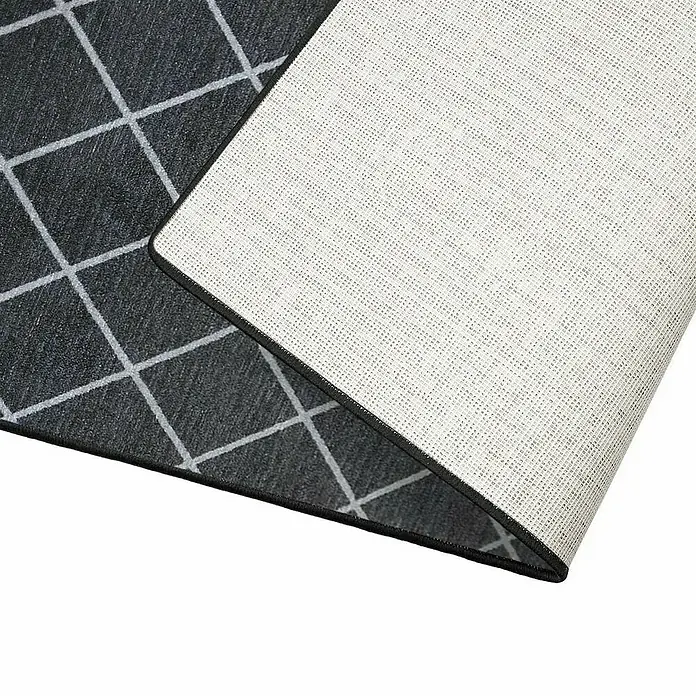 Teppichläufer Cosenza - Schwarz, 450 x 80 cm, 100 % Polyamid - Nahaufnahme eines Teppichs mit geometrischem Muster und schwarzer Umrandung, der auf einer weißen Oberfläche liegt.