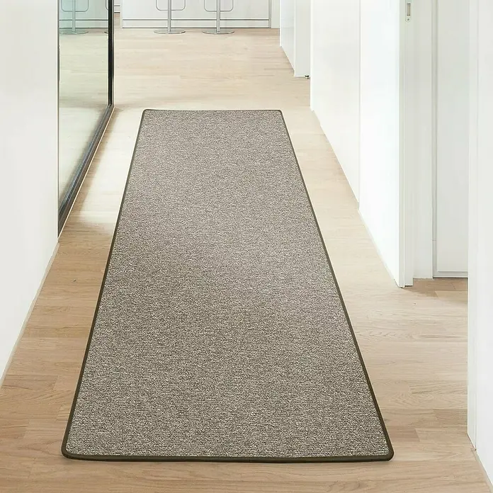 Flachgewebeteppich London - Hellbraun, 100 x 100 cm, 100 % Polypropylen - Ein langer, grauer Teppichläufer mit braunem Rand liegt in einem hellen Flur mit Holzboden und weißen Wänden. Ideal für Eingangsbereiche.
