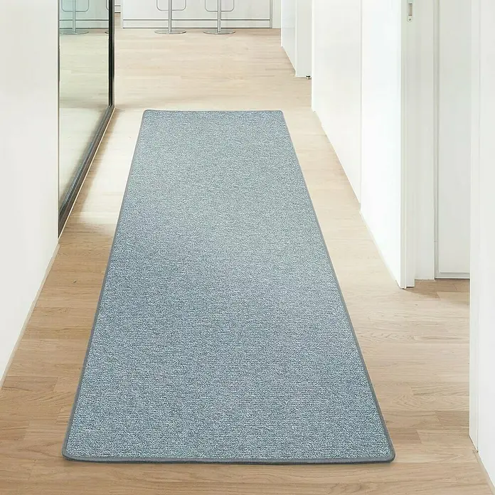 Flachgewebeteppich London - Hellgrau, 100 x 100 cm, 100 % Polypropylen - Ein blauer Teppichläufer liegt auf einem hellen Holzboden in einem modernen Flur. Der Läufer hat einen schlichten, aber stilvollen Look.