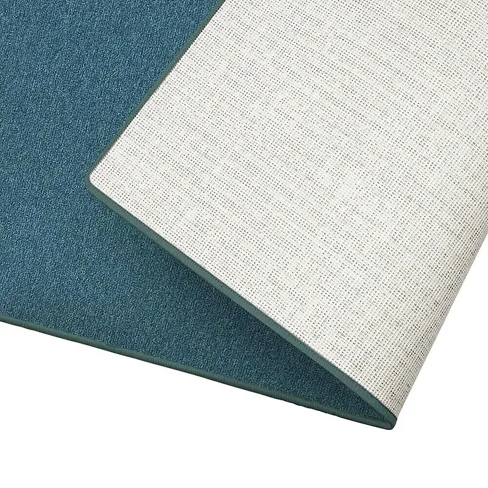 Flachgewebeteppich London - Grün, 100 x 100 cm, 100 % Polypropylen - Nahaufnahme einer blauen Teppichkante mit weißer Unterseite, die die Textur und Qualität des Teppichs hervorhebt.