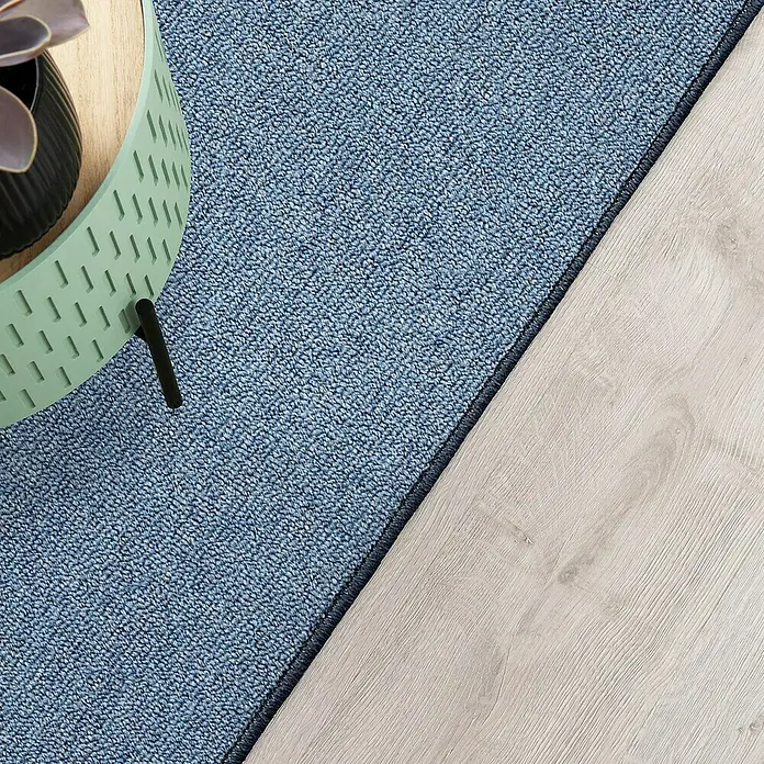 Flachgewebeteppich London - Hellblau, 200 x 200 cm, 100 % Polypropylen - Nahaufnahme eines blauen Teppichs neben einem hellen Holzboden, der eine elegante und moderne Atmosphäre schafft.