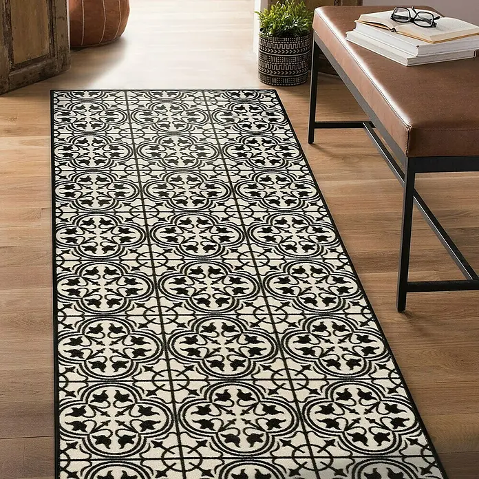 Teppichläufer Galway - Schwarz/Creme, 300 x 80 cm, 100 % Polyamid - Ein schmaler Teppich mit einem schwarz-weißen Fliesenmuster liegt auf einem Holzboden.