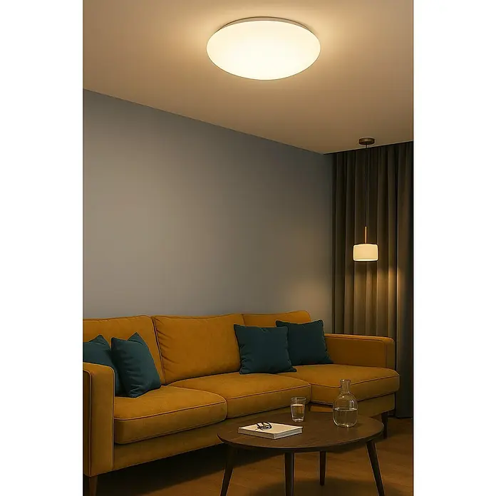 Trio Lighting Plafón LED redondo Putz - 15 W, Ø x Al: 40 x 10 cm, Blanco, Blanco cálido - Lámpara de techo en una sala de estar sobre un sofá con cojines y una mesa.