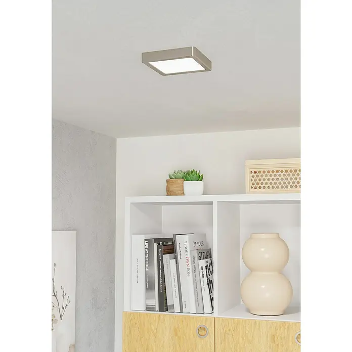 Eglo Fueva 6 Foco downlight de superficie LED - 7 W, L x An x Al: 15 x 15 x 2 cm, Bronce, Blanco frío - Primer plano de una moderna lámpara de techo cuadrada en un interior elegante con estantería.