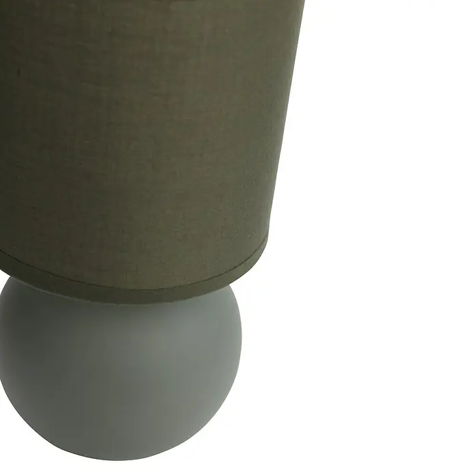 Idp Lampshades Lámpara de sobremesa redonda Loula - 40 W, Marrón, E14 - Primer plano de una lámpara moderna con una base redonda de color gris claro y una pantalla de color verde oliva. Diseño elegante.