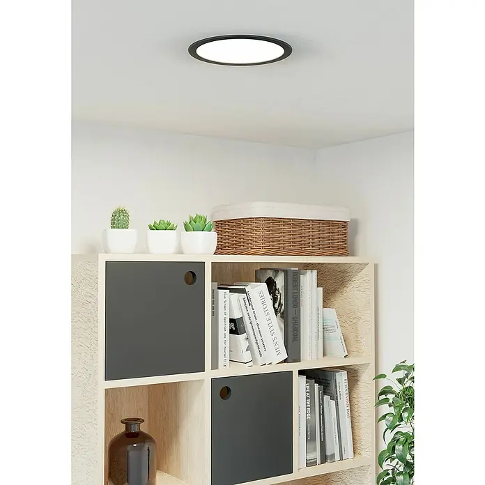Eglo Fueva 6 Downlight empotrable LED redondo - 12 W, Ø x Al: 21,6 x 3,1 cm, Negro, 2.700 K - 6.500 K, IP20 - Primer plano de una moderna estantería con elegantes decoraciones y una elegante lámpara de techo que realza la estética general de la habitación.