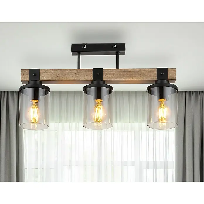 Globo Plafón Lila - 60 W, L x An x Al: 520 x 100 x 286 mm, Marrón, E27 - Lámpara de techo rústica con tres bombillas Edison y pantallas de vidrio transparente, montada sobre una viga de madera con detalles negros.