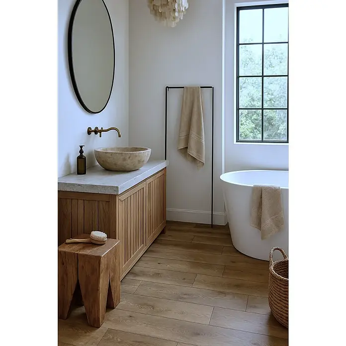 LOGOCLIC Aquaprotect Laminado Roble Hillside - 1.288 x 195 x 8 mm, Roble Hillside, AC4, Resistente al agua - Un baño con tocador de madera, espejo ovalado, bañera independiente y toallero, creando una estética moderna y natural.