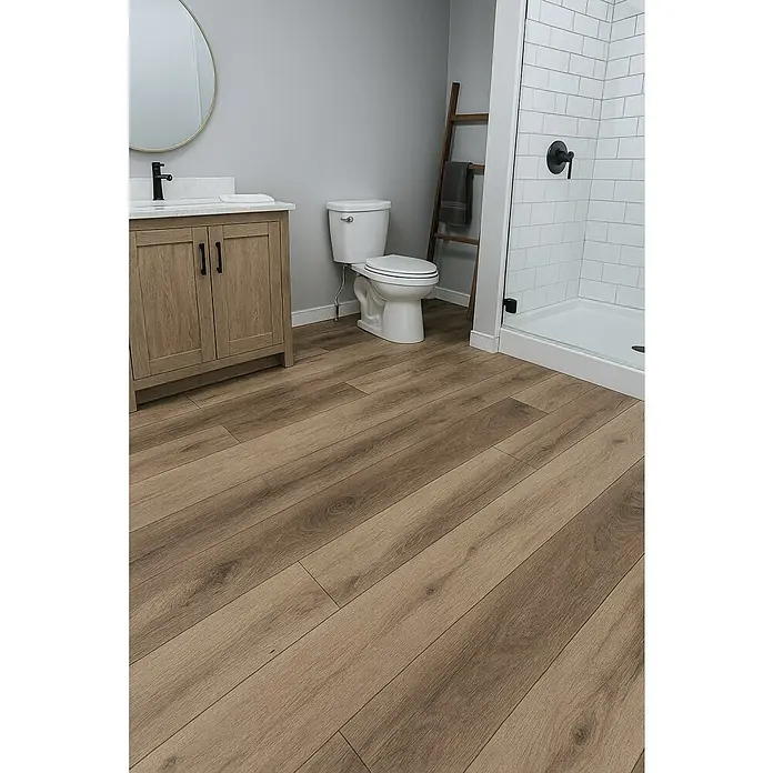 LOGOCLIC Aquaprotect Laminado Roble Wild West - 1.288 x 195 x 8 mm, Roble Wild West, AC5, Resistente al agua - Un baño con suelo de madera clara, tocador, inodoro y ducha. El suelo de madera añade calidez y un toque moderno al espacio.