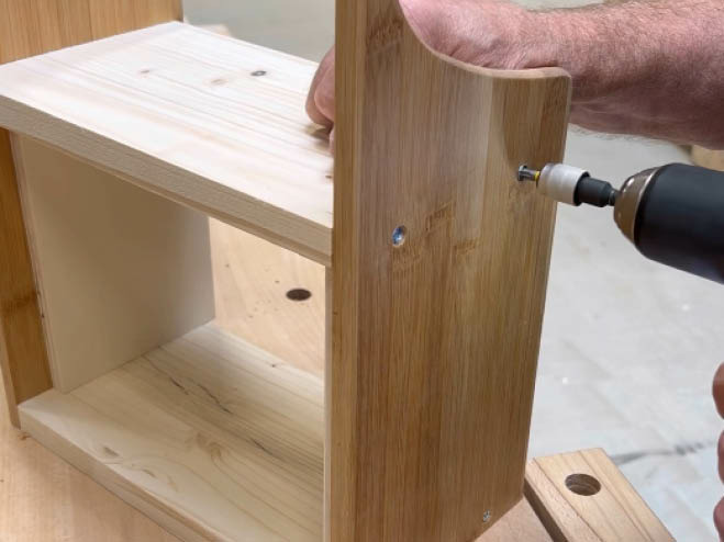 Eine Zwischenplatte wird an die 2 Teile des Holzbrettes geschraubt