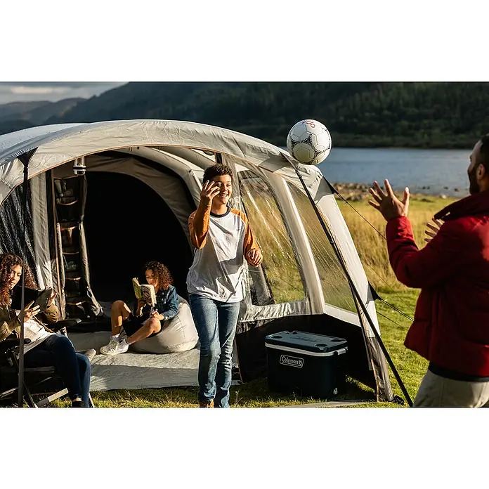 Coleman Kühlbox 52QT Xtreme™ - L x B x H: 56 x 42 x 47 cm, Blau, 49 l - Ein geräumiges Coleman-Zelt, vor dem eine Familie spielt, bietet viel Platz und Komfort für einen Campingausflug in der Natur.