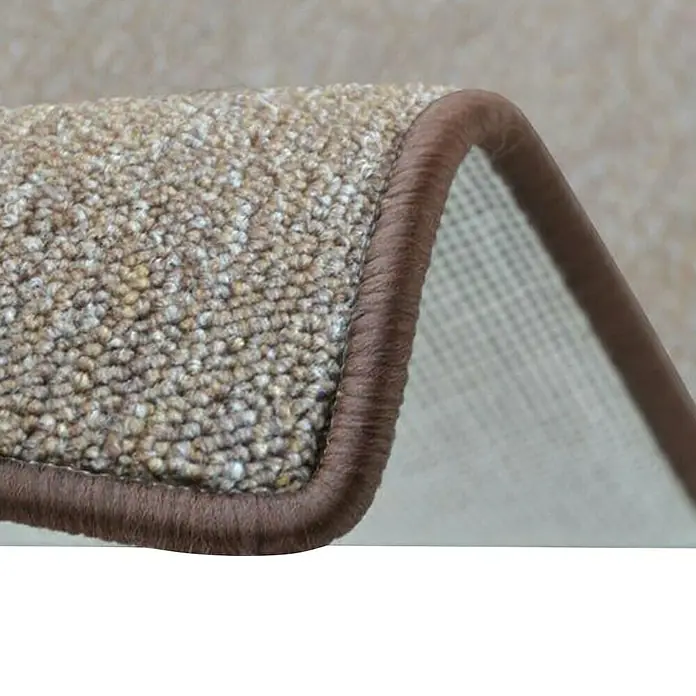Flachgewebeteppich London - Hellbraun, 100 x 100 cm, 100 % Polypropylen - Nahaufnahme eines beigefarbenen Teppichs mit brauner Umrandung, der die Textur und die Details des Materials hervorhebt.
