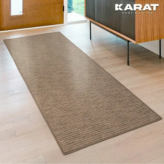 Flachgewebeteppich Geneva - Hellbraun, 200 x 200 cm, 100 % Polypropylen - Ein brauner Läufer mit einem horizontalen Streifenmuster liegt auf einem hellen Holzboden in der Nähe einer Tür und eines Schrankes.