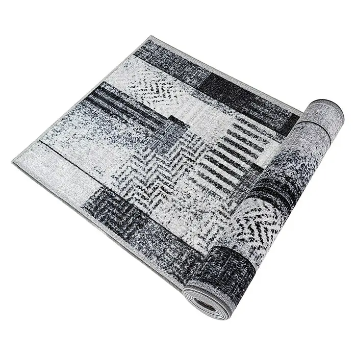 Teppichläufer Cordoba - Grau, 250 x 80 cm, 100 % Polyamid - Ein stilvoller, teilweise aufgerollter Teppich mit abstraktem Muster in Grau- und Schwarztönen. Perfekt für moderne Wohnräume.