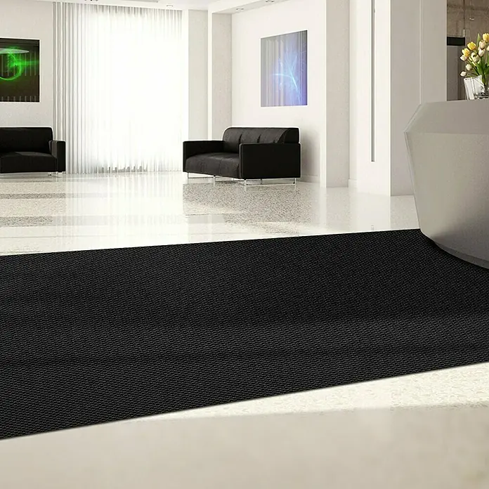 Schmutzfangmatte Hong Kong - Schwarz, 1.100 x 200 cm, 100 % Polypropylen - Ein schwarzer Teppich liegt auf dem Boden eines modernen Büros und bietet einen sicheren und stilvollen Eingangsbereich.
