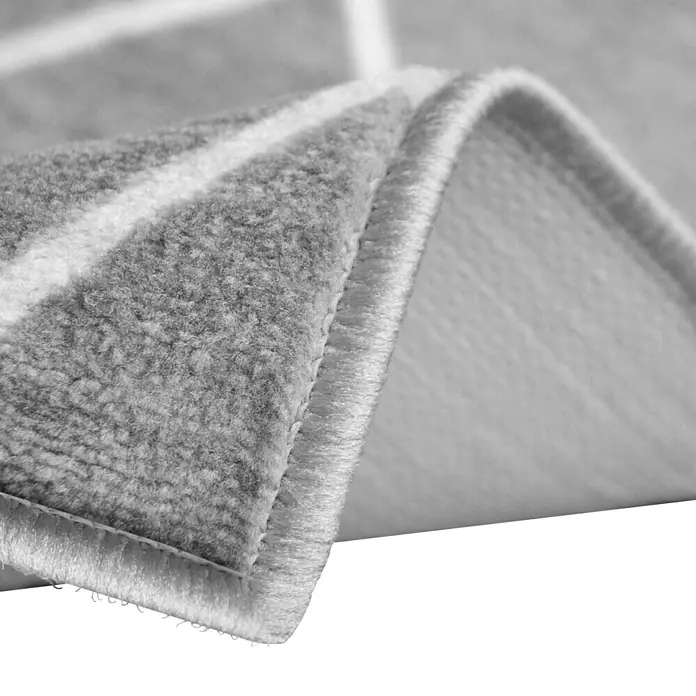 Teppichläufer Cosenza - Grau, 200 x 80 cm, 100 % Polyamid - Detailaufnahme eines grauen Teppichs mit weißem Muster, der die Textur und die Verarbeitung des Produkts hervorhebt.