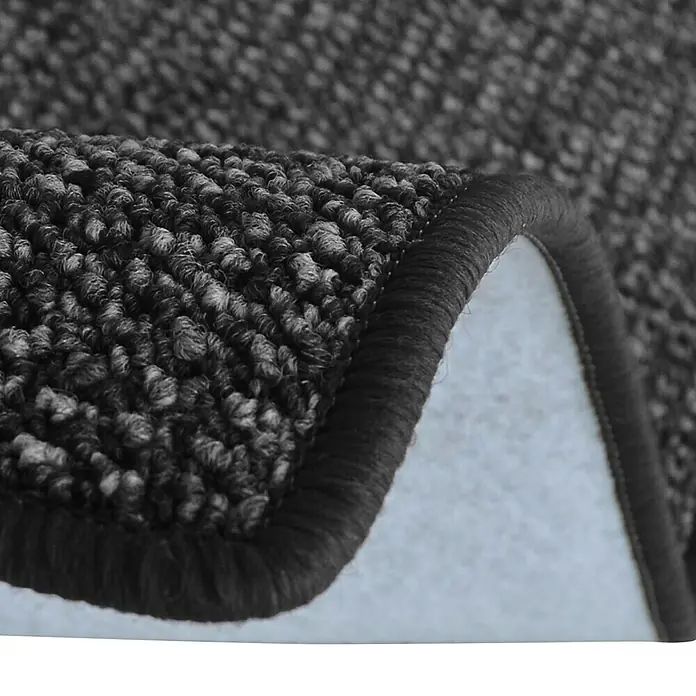 Flachgewebeteppich Carlton - Anthrazit, 200 x 200 cm, 100 % Polypropylen - Nahaufnahme eines gewebten Teppichs mit dunklen Farbtönen und einer umgeschlagenen Ecke, die die Textur und Verarbeitung zeigt.