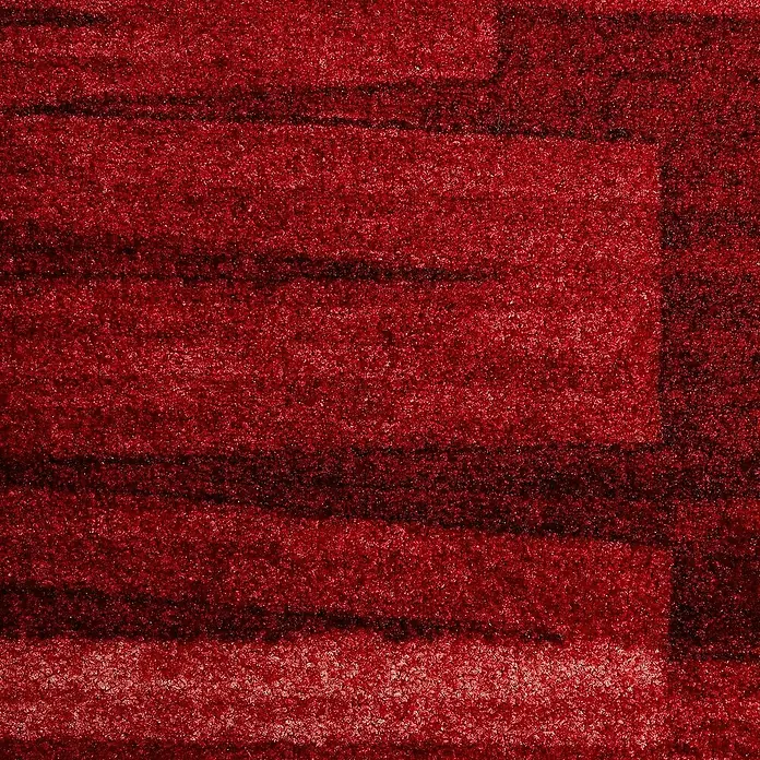 Kurzflorteppich Via Veneto - Rot, 100 x 100 cm, 100 % Polyamid - Detailaufnahme eines roten Teppichs mit dunkleren Streifen, der eine warme und strukturierte Oberfläche zeigt.