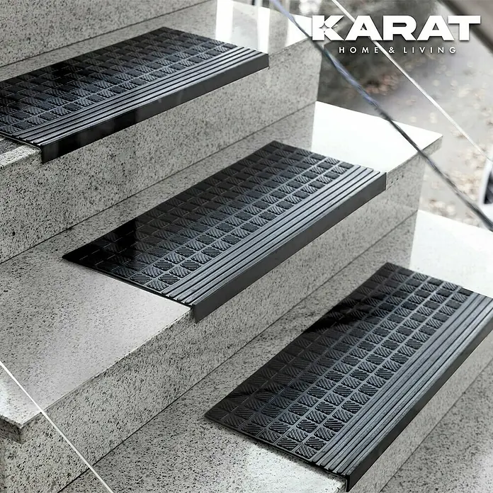 Stufenmatte Dia - 120 x 30 cm, 100 % Gummi, Schwarz - Detailaufnahme von schwarzen Treppenstufenmatten mit rutschfestem Muster, die auf hellen Steinstufen für mehr Sicherheit sorgen.