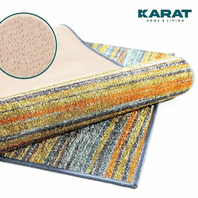 Teppichläufer Calama - Bunt, 250 x 80 cm, 100 % Polyamid - Nahaufnahme eines gestreiften Teppichs von Karat Home & Living, der aufgerollt ist und eine rutschfeste Unterseite zeigt.