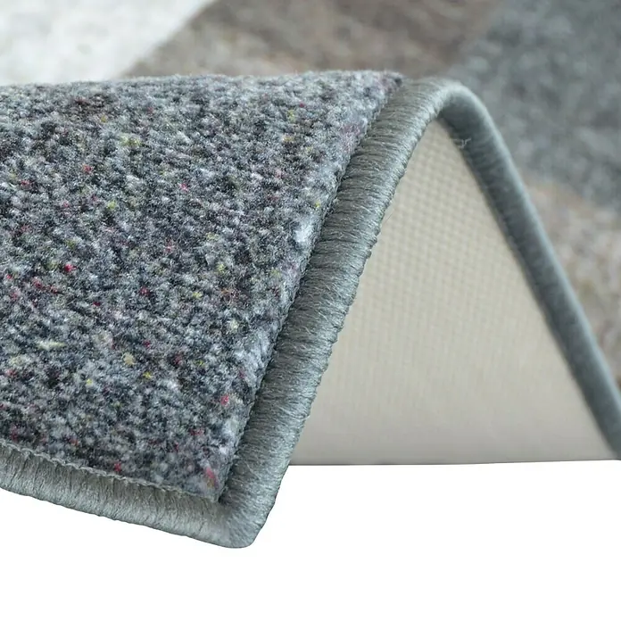 Teppichläufer Lucano - Beige, 200 x 80 cm, 100 % Polyamid - Nahaufnahme einer grauen Teppichkante, die die Textur und die Verarbeitung des Teppichs hervorhebt. Die Detailaufnahme zeigt die Qualität.