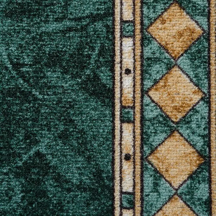 Teppichläufer Rügen - Grün, 100 x 80 cm, 100 % Polyamid - Detailaufnahme eines grünen Teppichs mit geometrischen Mustern. Ideal für Wohnbereiche, die Gemütlichkeit und Stil suchen.