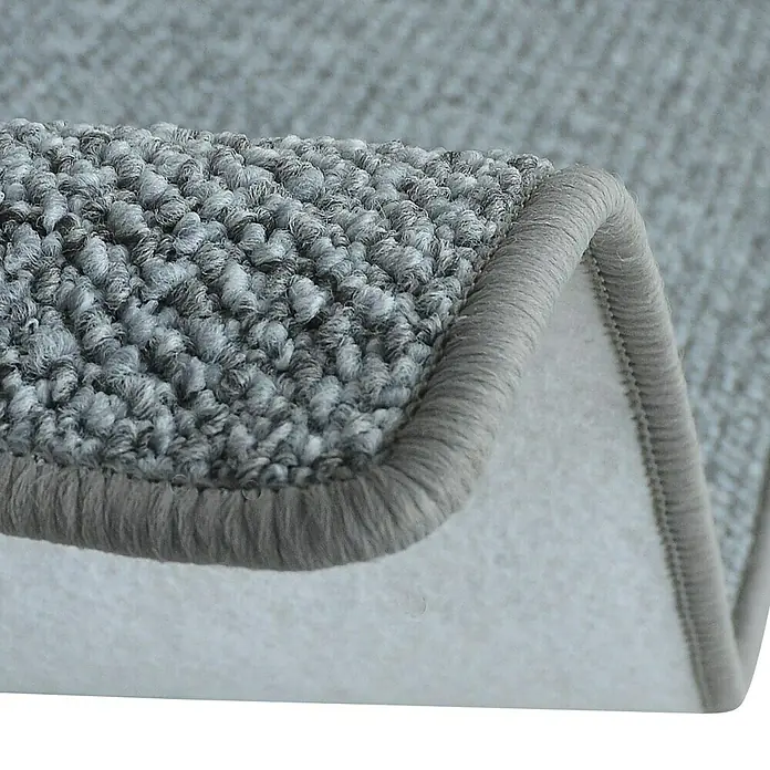 Flachgewebeteppich Carlton - Hellgrau, 200 x 200 cm, 100 % Polypropylen - Detailaufnahme eines grauen Teppichs mit gewebter Oberfläche und heller Unterseite, die die Textur und Verarbeitung hervorhebt.