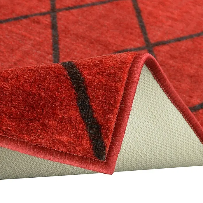 Teppichläufer Cosenza - Rot, 200 x 80 cm, 100 % Polyamid - Nahaufnahme eines roten Teppichs mit schwarzem Gittermuster, die die Textur und die Details der Unterseite zeigt.