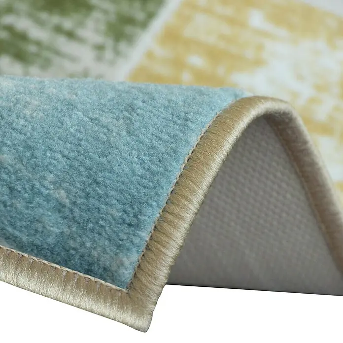 Teppichläufer Capera - Bunt, 100 x 80 cm, 100 % Polyamid - Detailansicht eines Teppichs mit blauem Flor, beiger Kante und farbigen Mustern. Die Textur des Teppichs ist gut erkennbar.