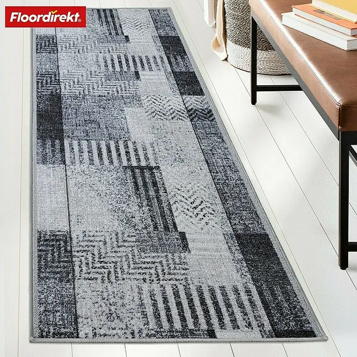 Teppichläufer Cordoba - Grau, 250 x 80 cm, 100 % Polyamid - Ein grauer Teppich mit geometrischen Mustern liegt auf einem weißen Holzboden.