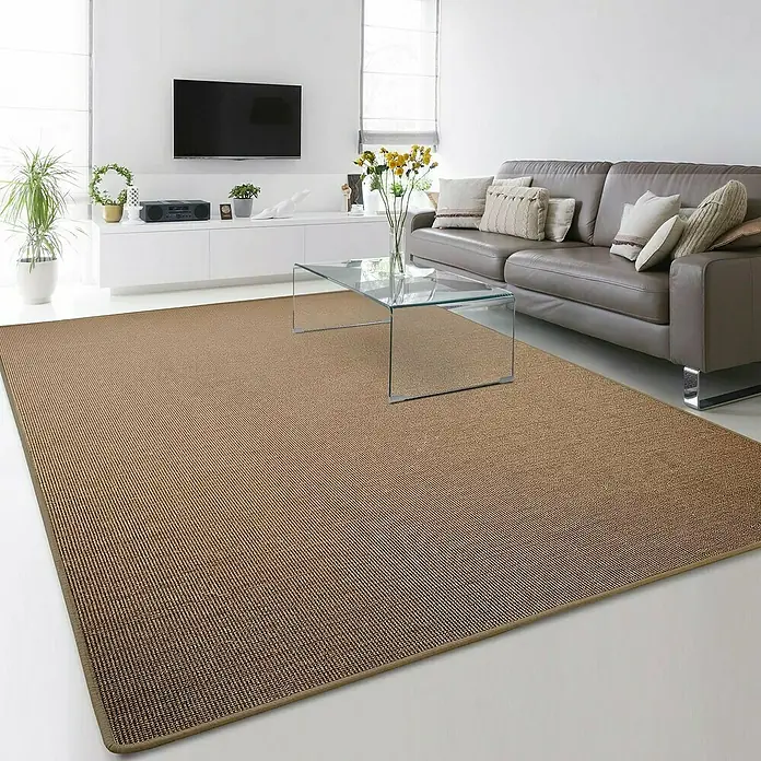 Flachgewebeteppich Sylt - Kork, 200 x 150 cm, 100 % Sisal - Brauner Sisalteppich liegt in einem modernen Wohnzimmer mit Couch und Tisch.