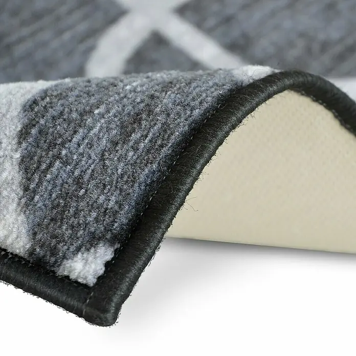 Teppichläufer Navelli - Schwarz, 150 x 80 cm, 100 % Polyamid - Detailaufnahme eines grauen Teppichs mit modernem Muster und schwarzer Umrandung, der die hochwertige Verarbeitung und das Design hervorhebt.