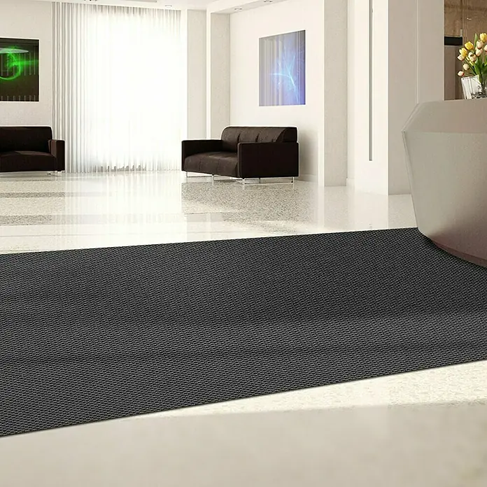 Schmutzfangmatte Hong Kong - Anthrazit, 1.100 x 200 cm, 100 % Polypropylen - Ein dunkler, strukturierter Läufer liegt in einem modernen Empfangsbereich, der den Eingangsbereich stilvoll hervorhebt.