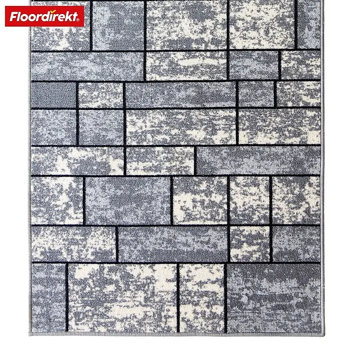 Teppichläufer Mannheim - Grau, 100 x 80 cm, 100 % Polyamid - Abstrakt gemusterter Teppich mit Ziegeldesign in Grau- und Beigetönen. Das "Floor direkt" Logo ist oben links zu sehen.