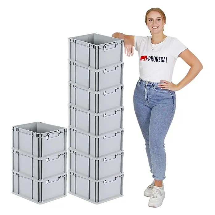 Proregal Euroboxen-Set 10x Eurobox NextGen Economy mit Auflagedeckel und 4x Verschlüsse Schwarz - Kunststoff, Grau, 10 Stk. - Bild von einer Frau, die neben zwei Stapeln Proregal-Lagerkisten steht. Die grauen Kisten sind robust und ideal für Lagerzwecke.