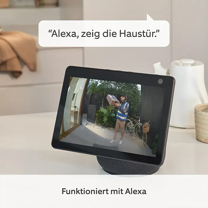 Ring Türklingel mit Kamera Pro Akku - 1.536 x 1.536 Pixel, 2,8 x 6,2 x 12,8 cm - Ein Amazon Echo Show mit der Aufschrift "Funktioniert mit Alexa" zeigt eine Live-Aufnahme einer Haustürkamera.